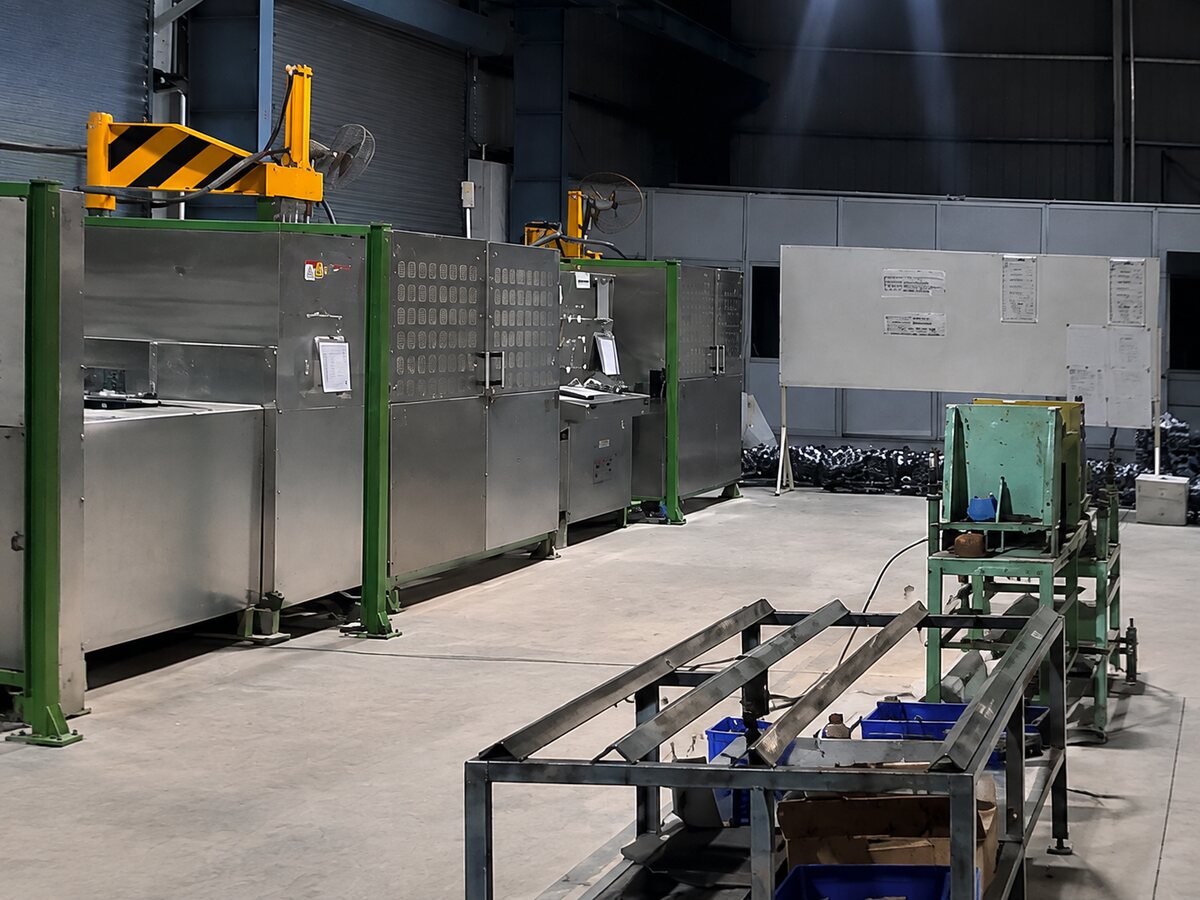 The row of stainless steel testing booths at Soudarshini Valve, served by an overhead crane